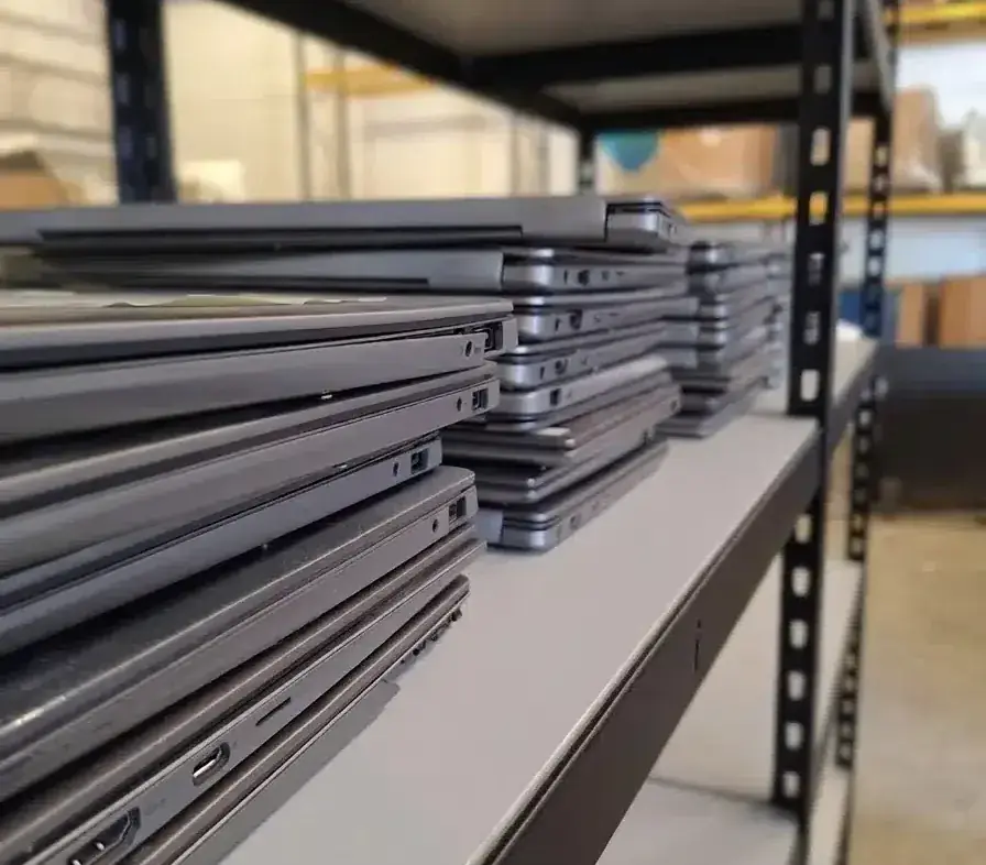 Computer laptops stacked at Premier IT Disposal Warehouse